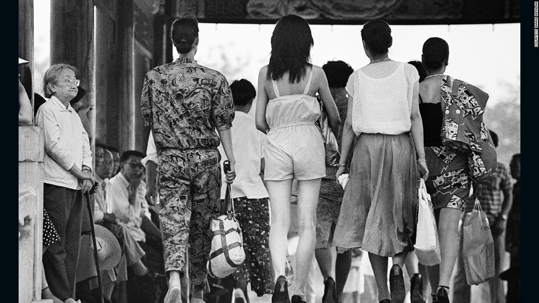 An old lady looks at pedestrians at Beijing&#39;s Longtanhu park in 1988. In the 1980s, Chinese women were liberated from the dull revolutionary uniforms and started to wear more feminine clothing.