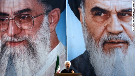 Iranian President Hassan Rouhani delivers a speech under portraits of Iran&#39;s supreme leader, Ayatollah Ali Khamenei (L) and Iran&#39;s founder of the Islamic Republic, Ayatollah Ruhollah Khomeini (R), on the eve of the 25th anniversary of the Islamic revolutionary leader Ayatollah Ruhollah Khomeini&#39;s death, at his mausoleum in a suburb of Tehran on June 3, 2014. AFP PHOTO / ATTA KENARE (Photo credit should read ATTA KENARE/AFP/Getty Images)