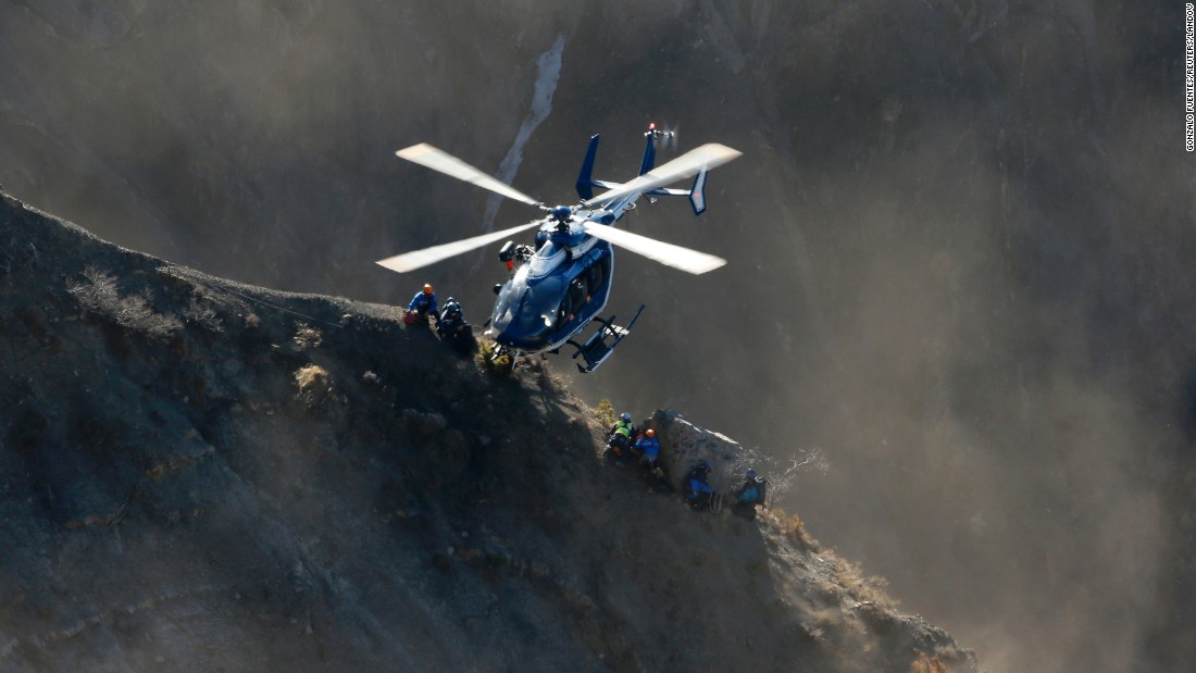 A helicopter drops rescue workers next to crash debris near Seyne-les-Alpes, France, on Sunday, March 29.