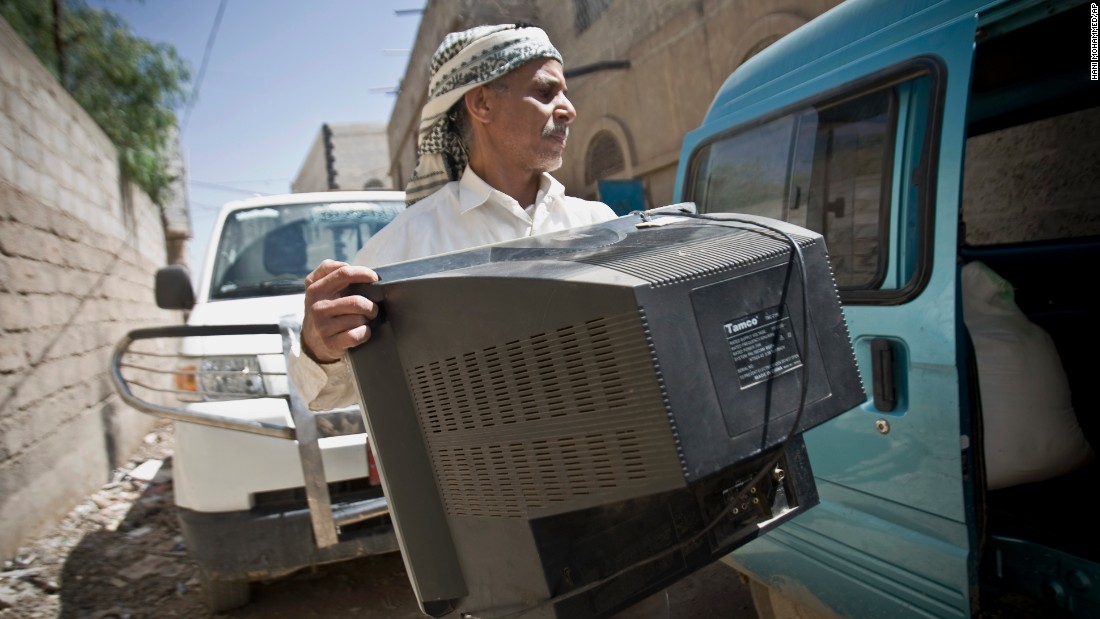 A Yemeni man loads a TV set into a van as he prepares to flee Sanaa on Thursday, April 2.