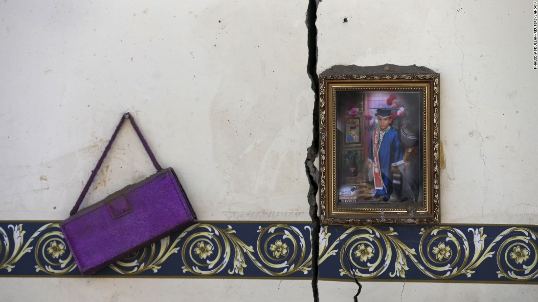 A framed photo and a purse hang on the wall of a house destroyed by an airstrike near the Sanaa airport on Tuesday, March 31.