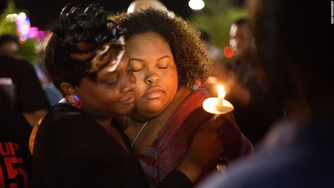 Chasyn Carter, right, embraces Candice Ancrum during a candlelight vigil outside North Charleston&#39;s City Hall on Wednesday, April 8.