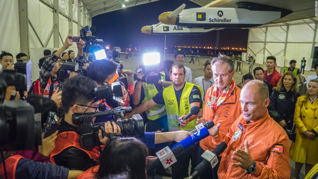 Borschberg and Piccard are welcomed by a crowd of reporters after landing in Chongqing.