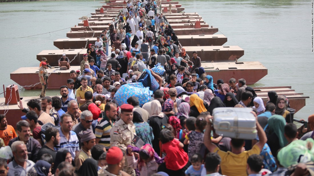 Thousands of Iraqis cross a bridge over the Euphrates River to Baghdad as they flee Ramadi on Friday, April 17.