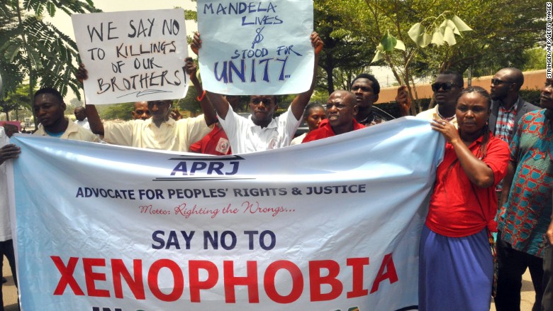 Demonstrators hold banners during a rally called by the NGO Advocate for Peoples' Rights and Justice in front of the office of the South African television DSTV, on April 20, 2015 in Abuja to protest against anti-immigrant violence that erupted last week in South Africa in the economic capital Johannesburg and Durban.