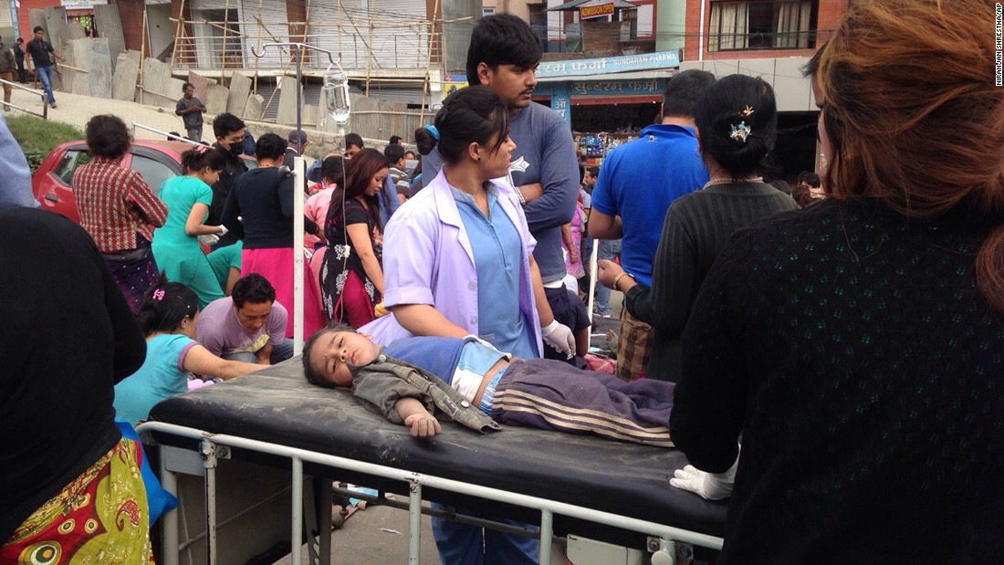 An injured child receives treatment outside Medicare Hospital in Kathmandu on April 25. Residents, after a relentless series of aftershocks, have been remaining outdoors.