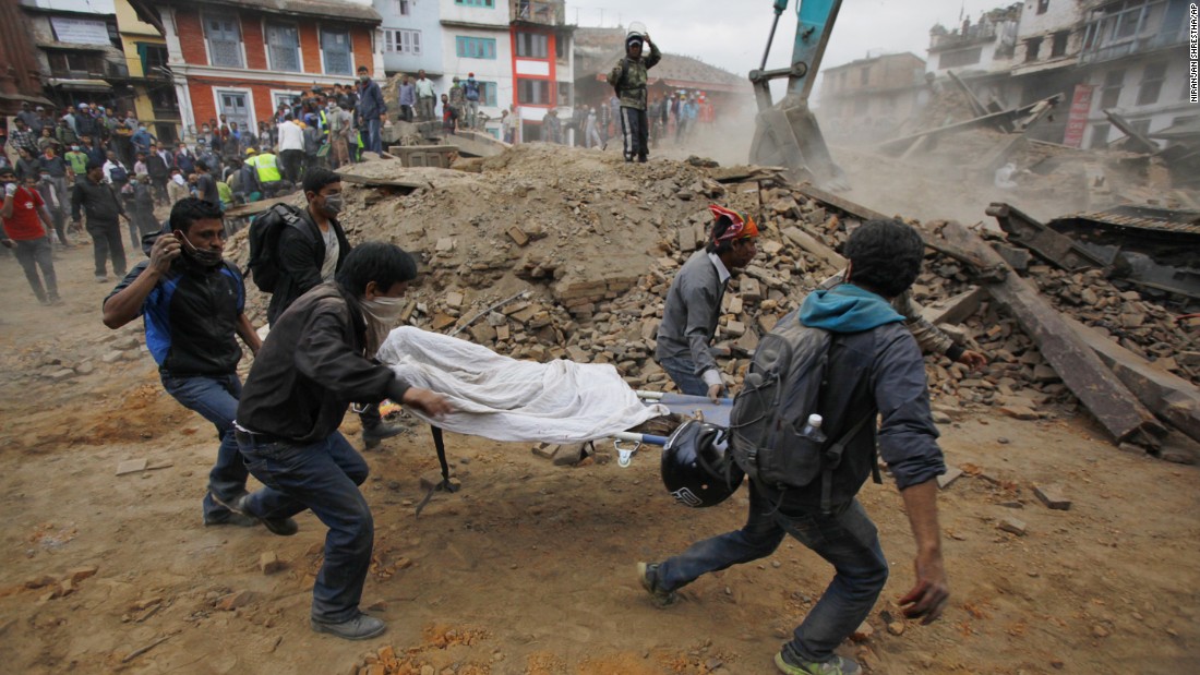 Volunteers carry a body recovered from the debris of a collapsed building in Kathmandu.