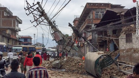 Pedestrians walk past collapsed buildings in Kathmandu, Nepal, on April 25. 