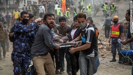 Emergency rescue workers carry a victim on a stretcher after Dharara tower collapsed on April 25, 2015 in Kathmandu, Nepal.