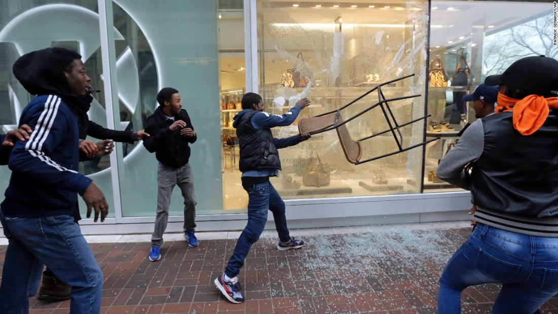 A protester breaks a store window after the rally in Baltimore on April 25.