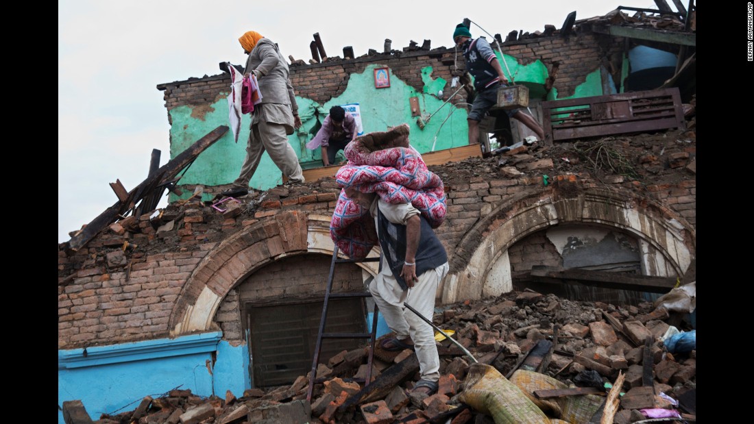 Residents rescue items from the debris of houses damaged in the quake in Kathmandu on April 27.