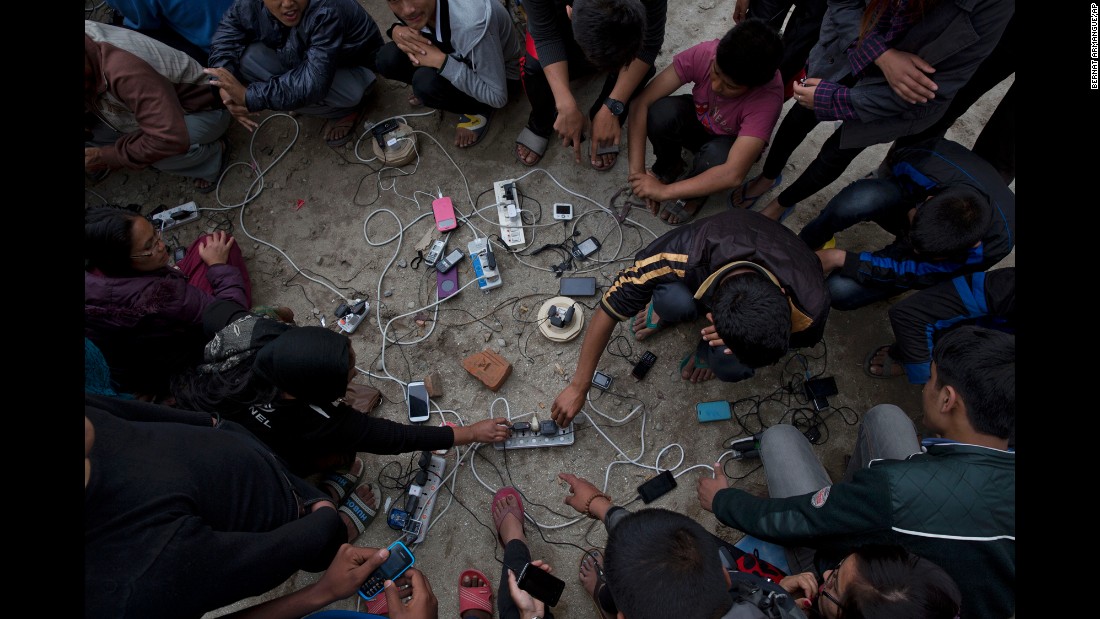 People charge their cell phones in an open area in Kathmandu on April 27.