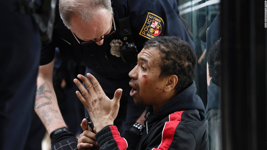 A police officer checks on a man who was injured on April 27.