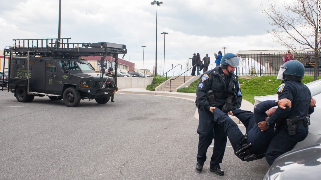 A police officer is carried to safety after being hit in the head with a rock during the riot on April 27. 