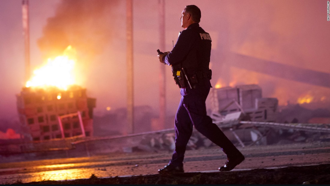 A police officer walks by a burning building on April 27.