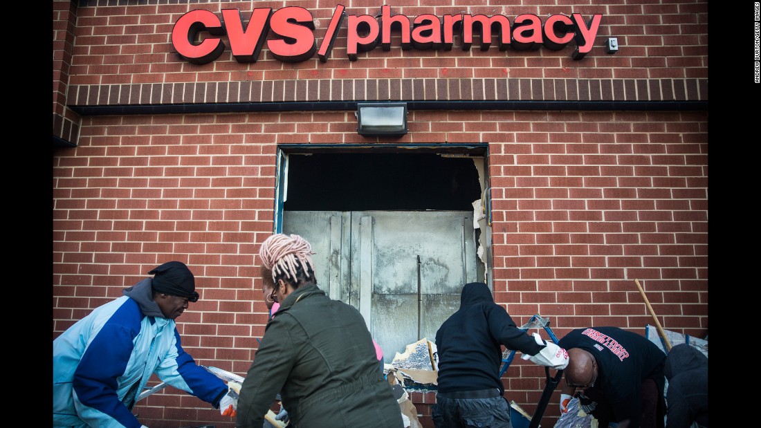 Members of the community clean up debris on April 28 from the CVS that was burned and looted in the riots.