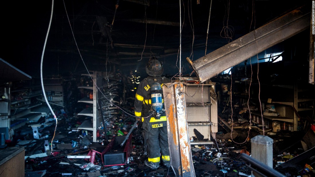 Baltimore firefighters inspect a burned store on April 28.