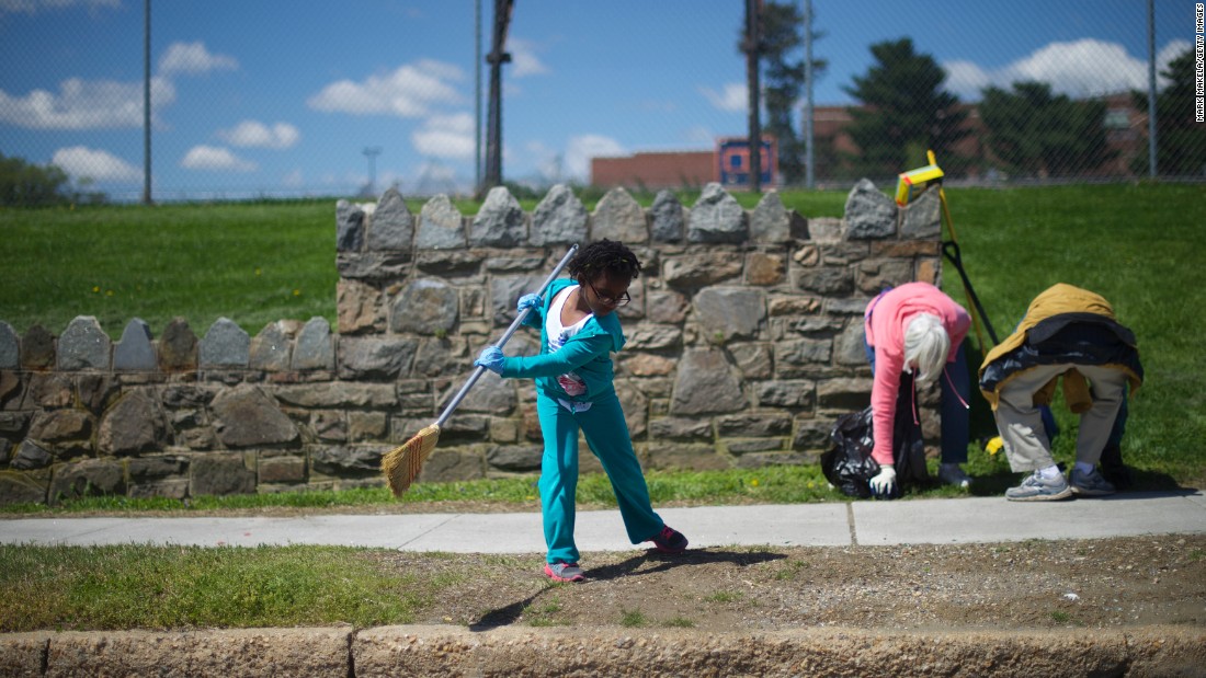 Kailah Johnson, 5, joins her mother in a neighborhood cleanup on April 28. Schools were closed across the city.