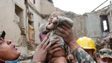 In this Sunday, April 26, 2015, photo taken by Amul Thapa and provided by KathmanduToday.com, four-month-old baby boy Sonit Awal is held up by Nepalese Army soldiers after being rescued from the rubble of his house in Bhaktapur, Nepal, after Saturday&#39;s 7.8-magnitude earthquake shook the densely populated Kathmandu valley.  Thapa says that when he saw the baby alive after 20 hours of rescue efforts &quot;... all my sorrow went. Everyone was clapping. It gave me energy and made me smile in spite of lots of pain hidden inside me.&quot; (Amul Thapa/KathmanduToday.com via AP)