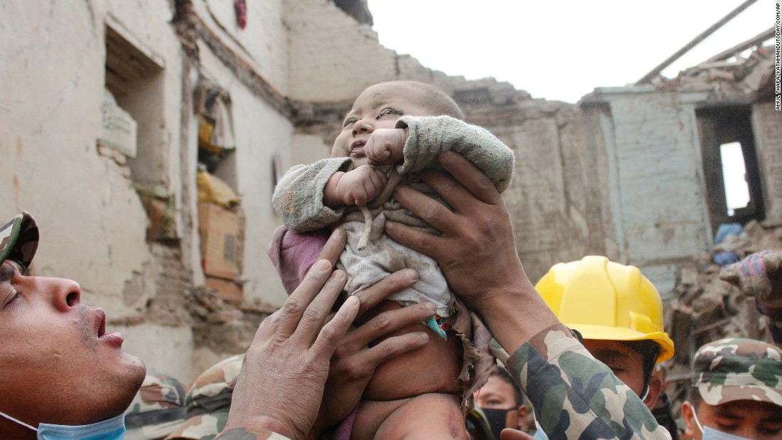 Four-month-old Sonit Awal is held up by Nepalese army soldiers after being rescued from the rubble of his house in Bhaktapur, Nepal, on April 26.