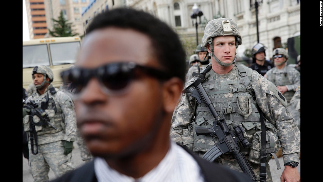 A member of the National Guard stands outside Baltimore City Hall as protesters gather on Wednesday, April 29.