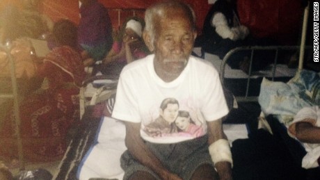 Funchu Tamang, 101, sits at a hospital in Nuwakot district on Sunday after being rescued from his collapsed home.