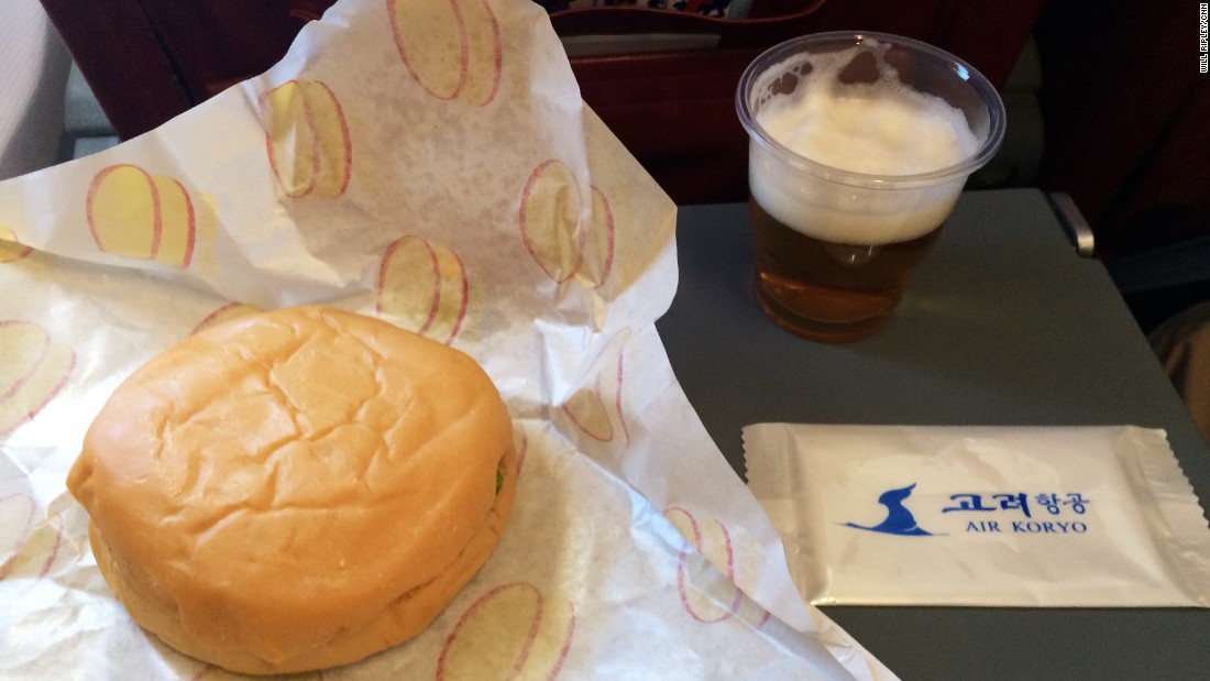 The inflight meal consists of a burger and a glass of North Korean beer.  