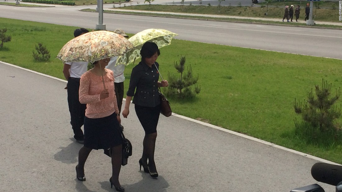 Pyongyang women wear their Sunday best -- and carry ornate umbrellas to shield themselves from the sun.