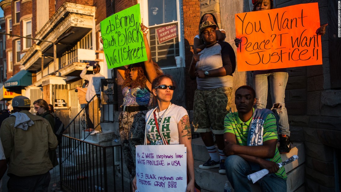 Protesters hold signs on May 2 in the Sandtown neighborhood.