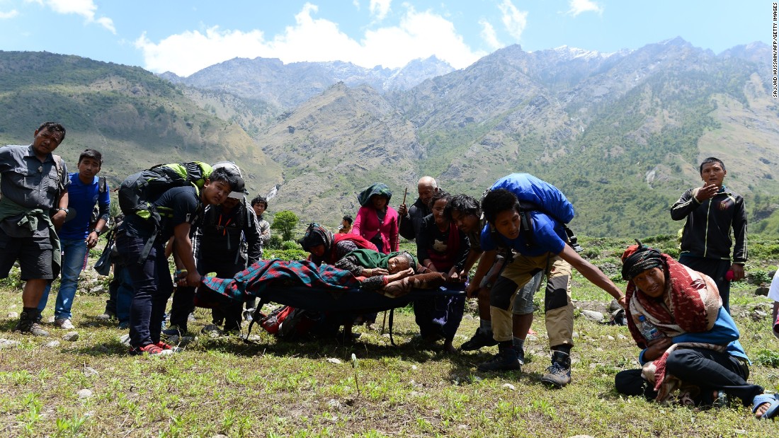 An injured Nepalese woman is carried by villagers toward an Indian army helicopter to be airlifted from Philim village in Gorkha district in Nepal on May 3.