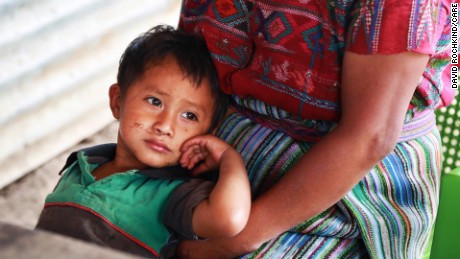  Hector leans against his mother at their rural home in Estancia de la Virgen. 