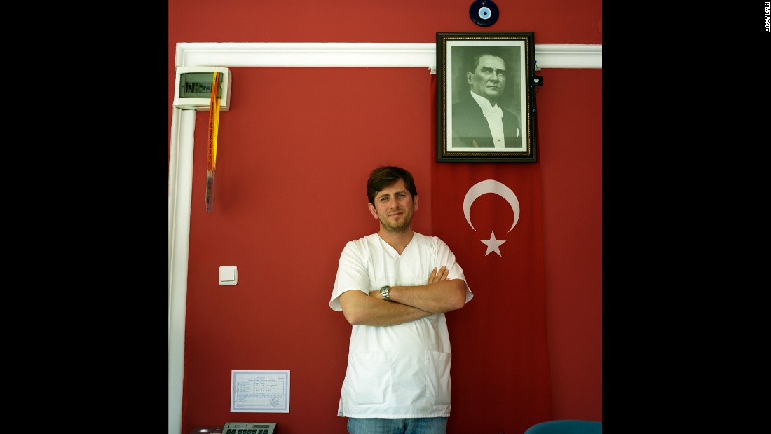 A nurse at a private clinic specializing in care for the elderly in Antalya poses beneath Ataturk&#39;s portrait. According to Emin, the whole reception room was painted a patriotic red. 