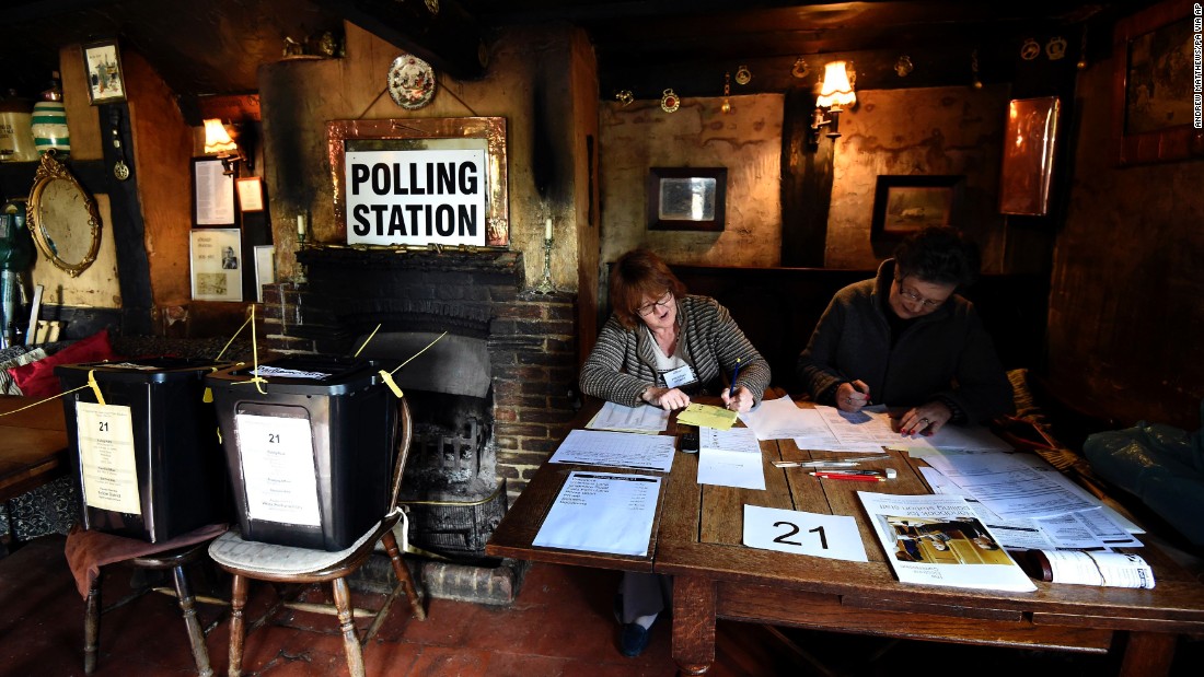 Election officials work at a polling station in the White Horse Inn in Priors Dean, England.