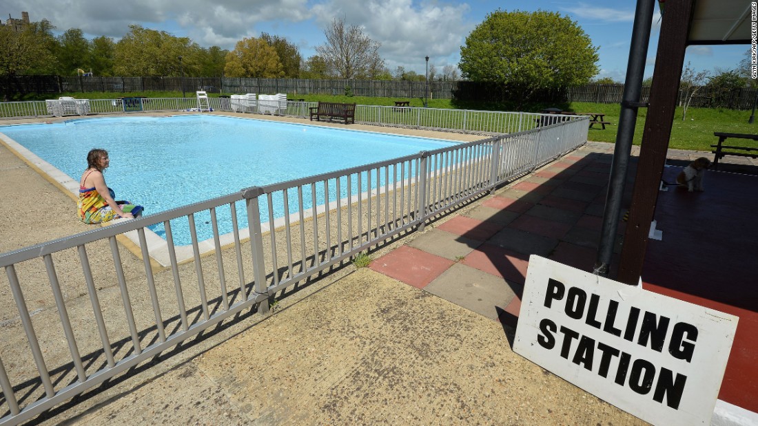 A woman sits by a swimming pool at a temporary polling station in Arundel, England.