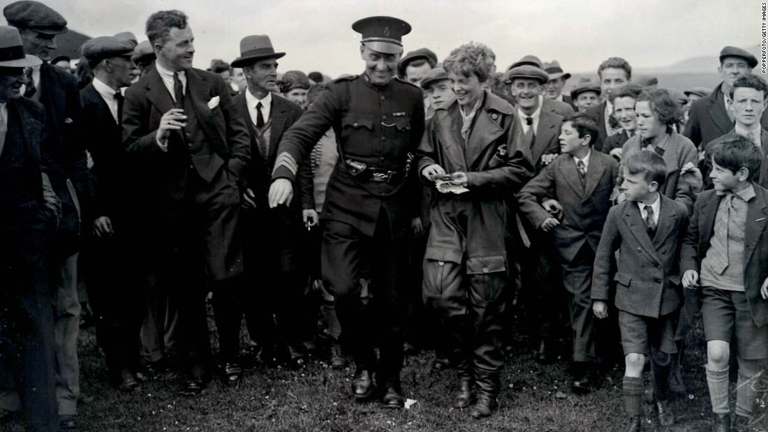 Earhart is escorted from her plane by a policeman in Londonderry, Northern Ireland, on May 23, 1932. Prior to completing the solo flight, Earhart was the first woman to fly across the Atlantic as a passenger in 1928.