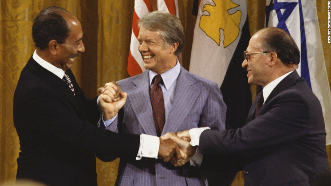Egyptian President Anwar Sadat, left, joins hands with Israeli Prime Minister Menachem Begin, right, on September 18, 1978, after the Camp David Accords were signed in Maryland. After 12 days of secret meetings, the two sides agreed upon a step toward peace. U.S. President Jimmy Carter, center, personally led the lengthy negotiations and discussions between the two parties.