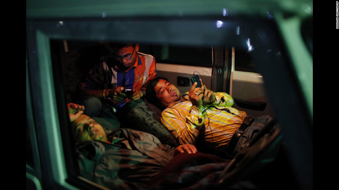 People take shelter inside a car instead of being indoors in Kathamandu on May 12.