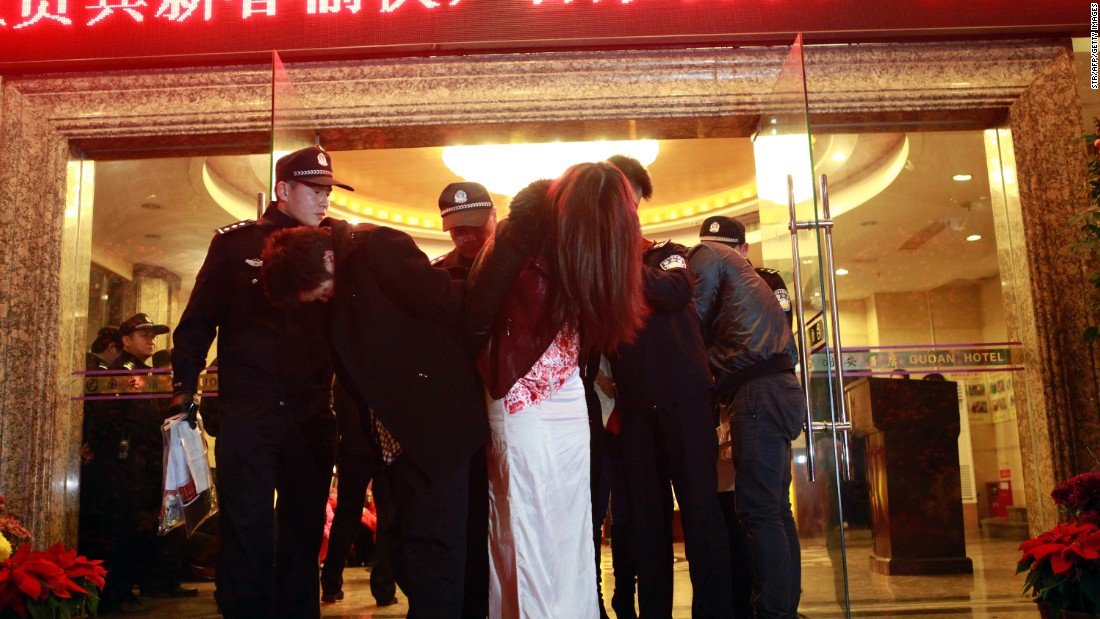 This picture taken late on February 9, 2014 shows Chinese police taking away alleged sex workers and clients at an entertainment center in Dongguan, sometimes called China&#39;s &quot;Sin City.&quot; 