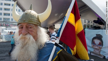 A Malmo resident dressed in a viking costume holds a composite &#39;scandinavian&#39; flag at a Eurovision public viewing area in downtown Malmo ahead of the finals of the 2013 Eurovision Song Contest on May 18, 2013. 