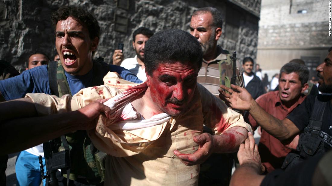 Rebel fighters with the Free Syrian Army capture a police officer in Aleppo, Syria, who they believed to be pro-regime militiaman on July 31, 2012. Dozens of officers were reportedly killed as rebels seized police stations in the city.