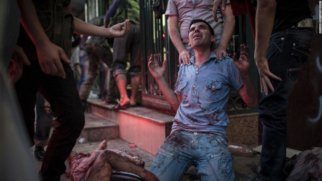 Family members mourn the deaths of their relatives in front of a field hospital in Aleppo on August 21, 2012.