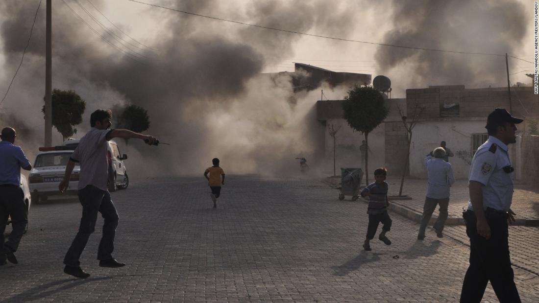 Smoke rises over the streets after a mortar bomb from Syria landed in the Turkish border village of Akcakale on October 3, 2012. Five people were killed. In response, Turkey fired on Syrian targets and its parliament authorized a resolution giving the government permission to deploy soldiers to foreign countries.