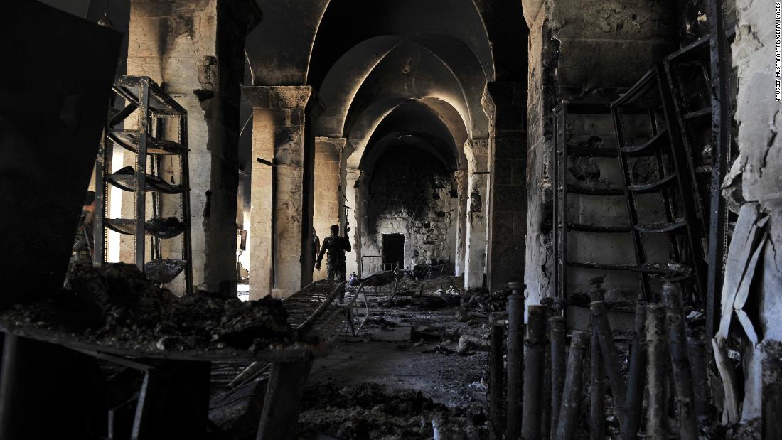 A Syrian rebel walks inside a burnt section of the Umayyad Mosque in Aleppo hours before the Syrian army retook control of the complex on October 14, 2012.