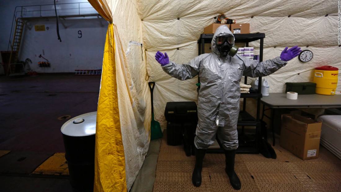 A US ship staff member wears personal protective equipment at a naval airbase in Rota, Spain, on April 10, 2014. A former container vessel was fitted out with at least $10 million of gear to let it take on about 560 metric tons of Syria&#39;s most dangerous chemical agents and sail them out to sea, officials said.