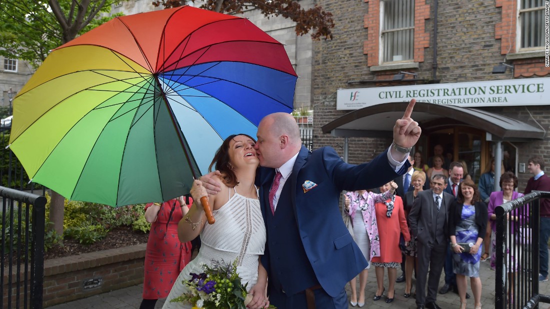 Newly married couple Anne and Vincent Fox kiss in Dublin on Friday, May 22, under a rainbow umbrella, showing their support for the &quot;yes&quot; side in the same-sex marriage referendum.&lt;br /&gt;