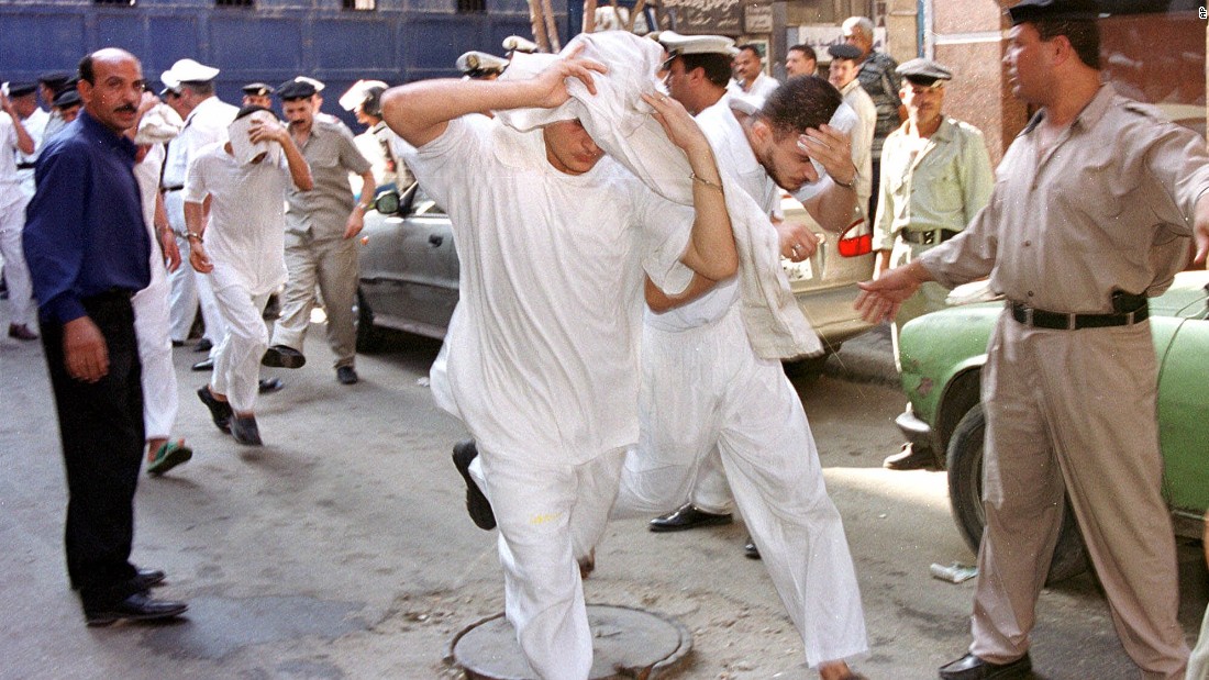 About 50 men accused of breaking laws covering obscenity and public morality cover their faces as they enter a state security court for their trial in Cairo, Egypt in July, 2001. 