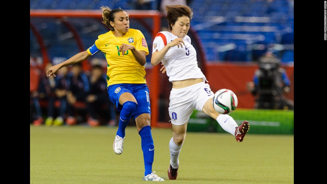 South Korea&#39;s Kim Do-yeon tries to move the ball past Marta. 