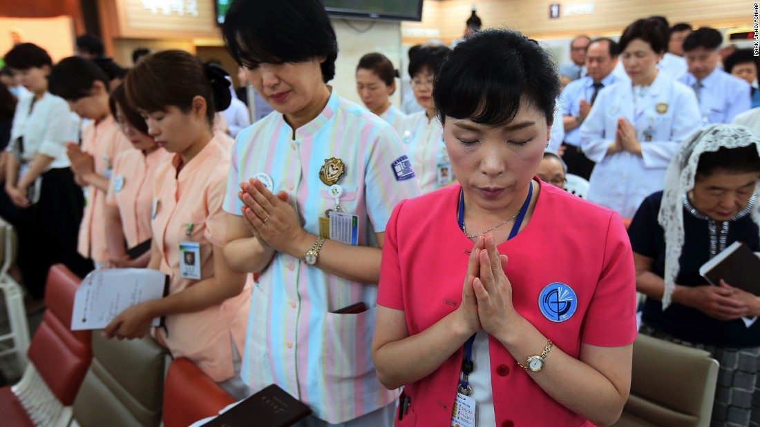 Hospital workers pray as they attend a special service for patients suffering from MERS, at a Sungmo hospital in Seoul, South Korea on Friday, June 12, 2015. 