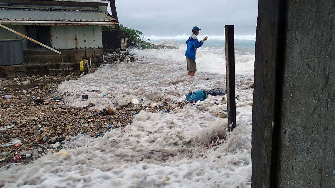 This photo taken on March 3, 2014 shows a resident surrounded by the on-rushing high tide energized by a storm surge that damaged a number of homes across Majuro.   It was the third inundation of the Marshall&#39;s capital atoll in the past 12 months. The Marshall Islands has put climate change at the top of its political and diplomatic agenda and officials saw the recently held Cartagena Dialogue as an opportunity to gather momentum.      AFP PHOTO / Karl Fellenius        (Photo credit should read Karl Fellenius/AFP/Getty Images)