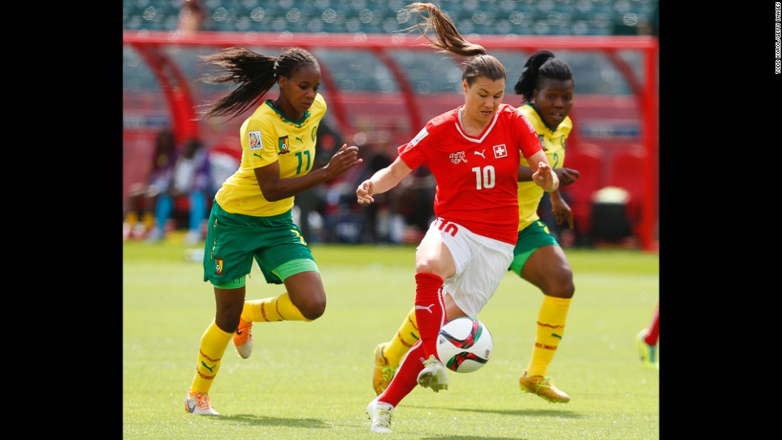 Ramona Bachmann of Switzerland breaks past two Cameroon players.